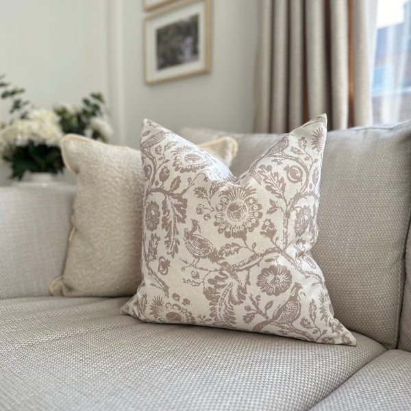 square cream cushion with a large beige floral and bird print.