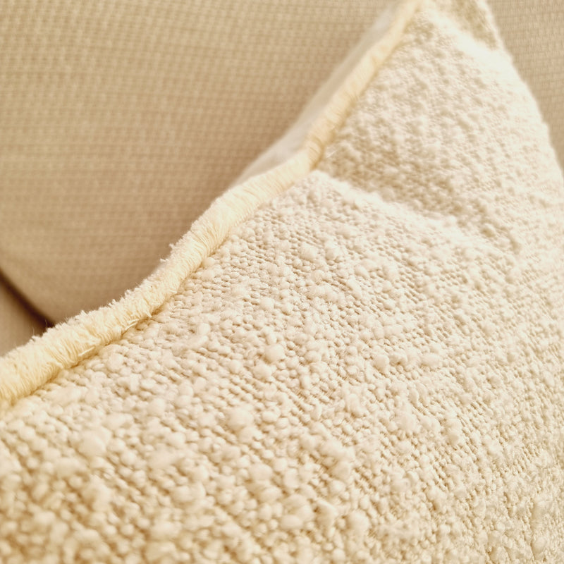 close up of cream boucle and frayed edge cushion