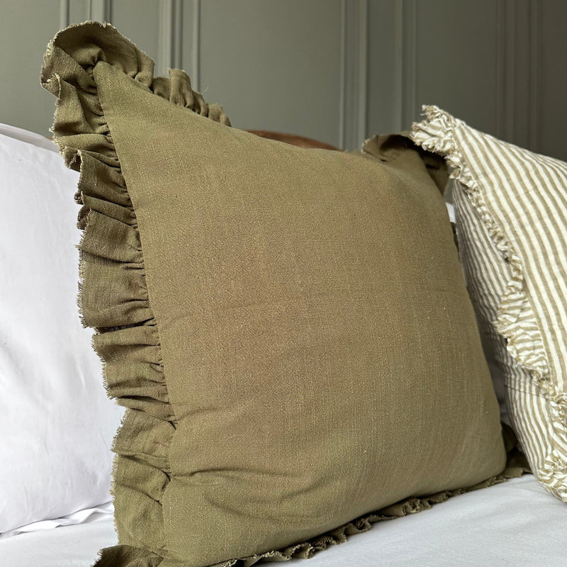 close up of olive green square cushion with ruffled edge