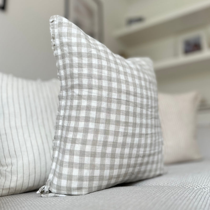 Side profile of a cream cushion with an all over beige gingham print.