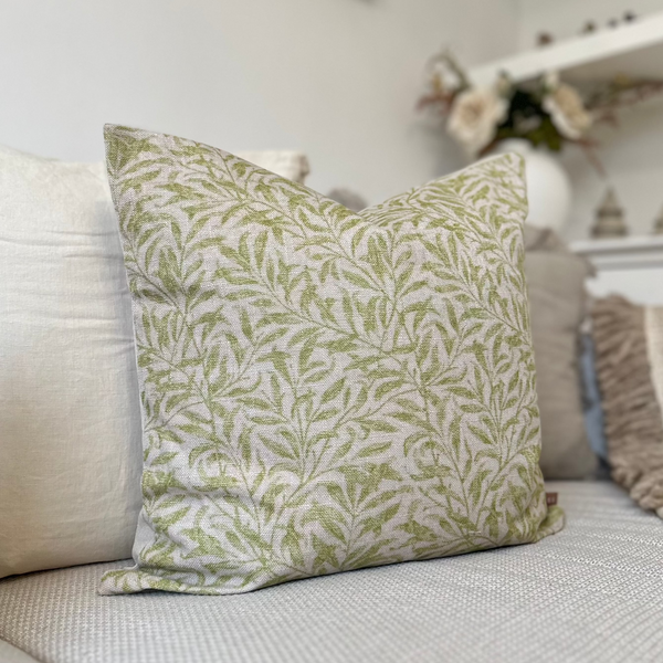 beige coloured square cushion with a repeating small leaf print pattern