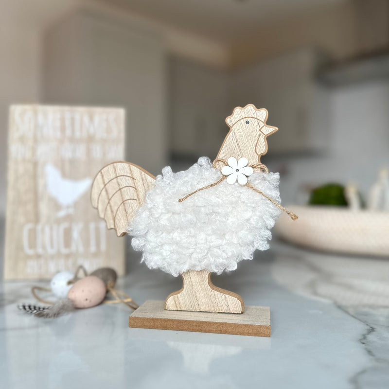 decorative wooden chicken with white fluffy body and a wooden daisy necklace