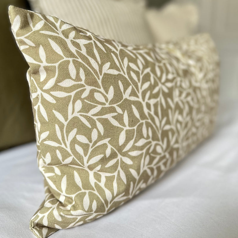 close up of a rectangle olive green cushion with a cream olive leaf print