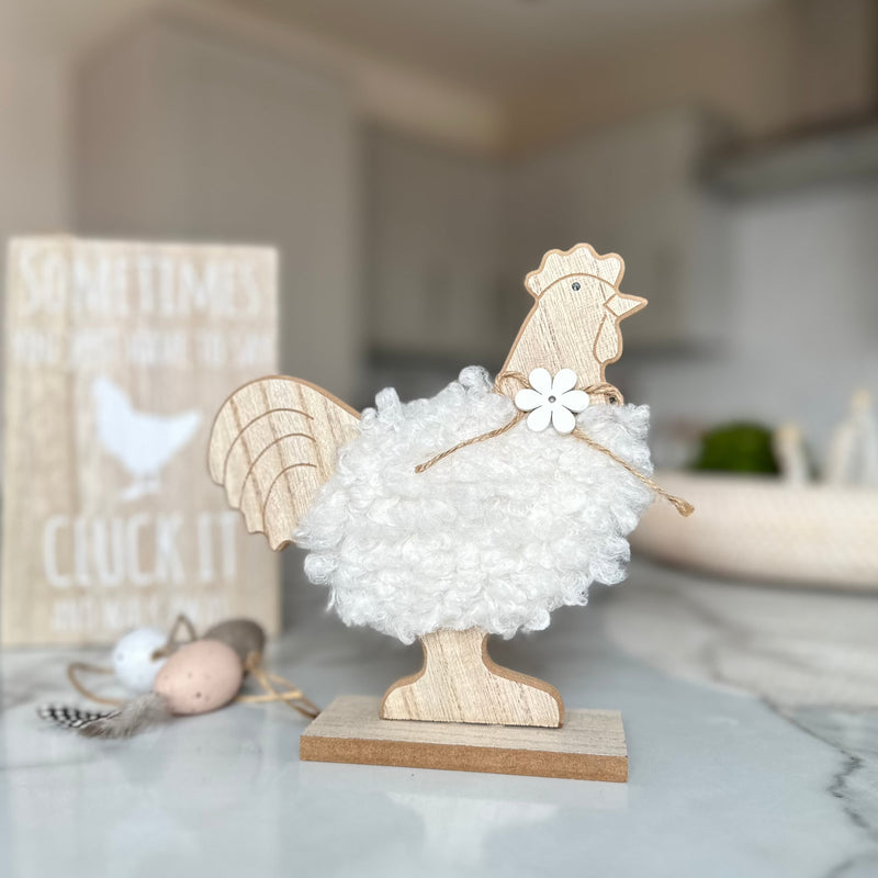 decorative wooden chicken with white fluffy body and a wooden daisy necklace