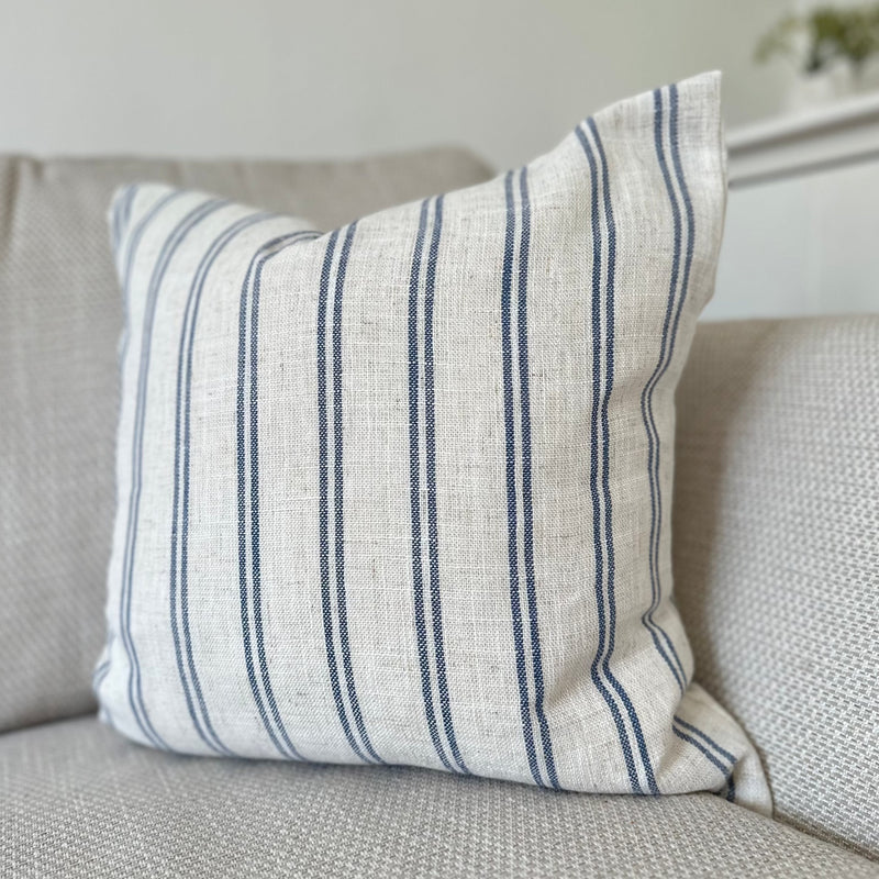 Light cream cushion with navy blue vertical double stripe motif all the way around the cushion.