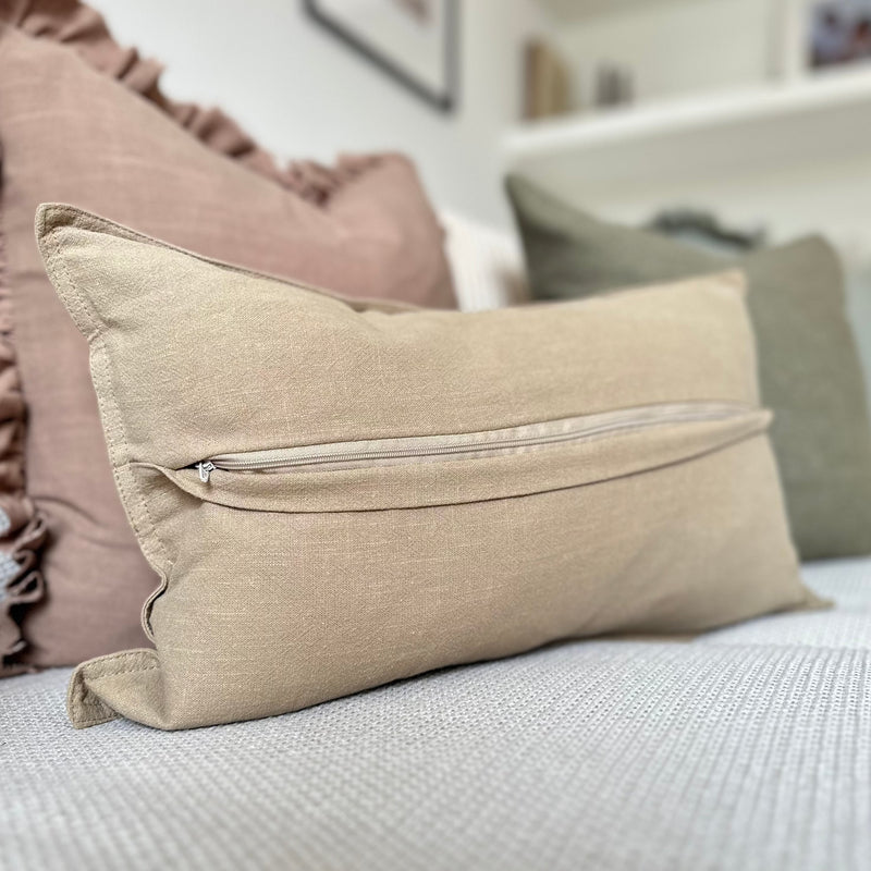 showing the back of a sand coloured rectangle linen cushion.