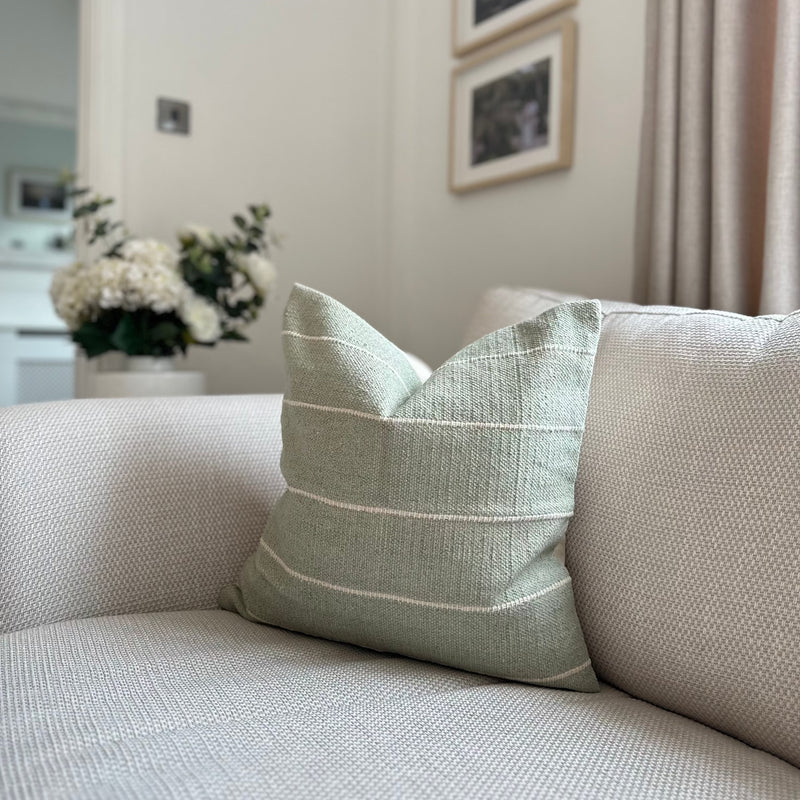 Duck Egg soft Green Square Cushion with Horizontal cream stripe throughout. Sat on a cream sofa