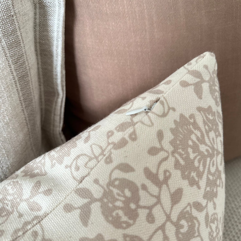 close up of zip on rectangle cream cushion with beige floral detail