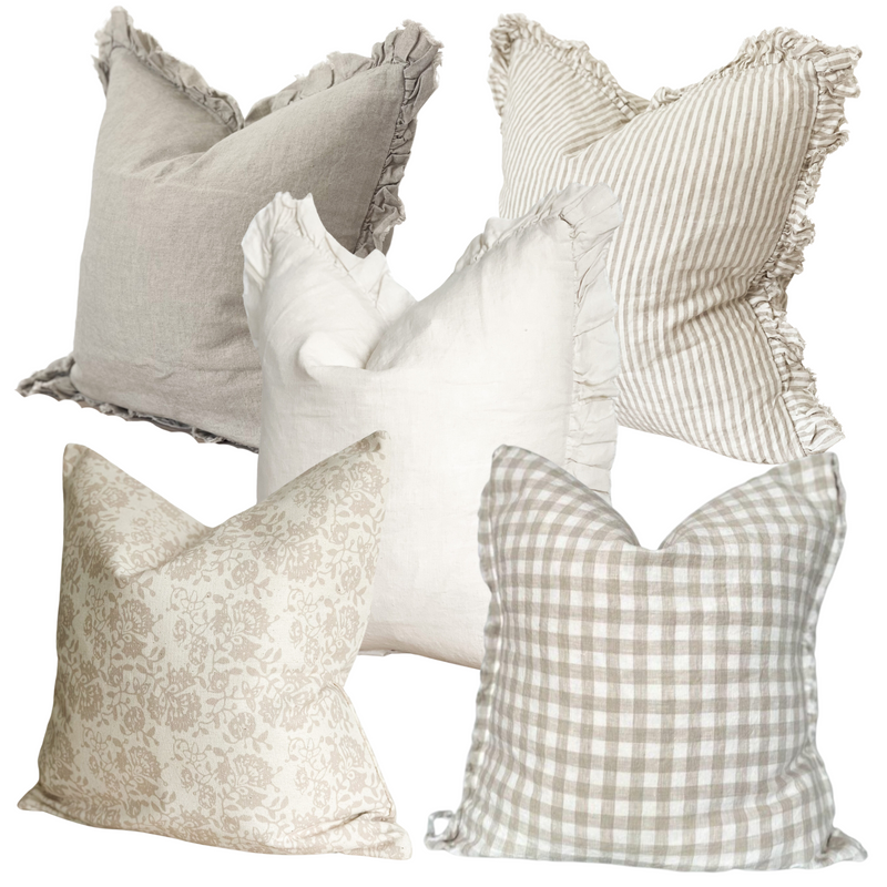 Set of 5 English country inspired cushions. all square. 1 beige ruffled edge linen cushion. 1 cream with beige stripes and a ruffled edge linen cushion. 1 Cream ruffled edge linen cushions, 1 x cotton cream with beige floral print, 1 weathered edge cream and beige gingham linen cushion. All on a plain white background