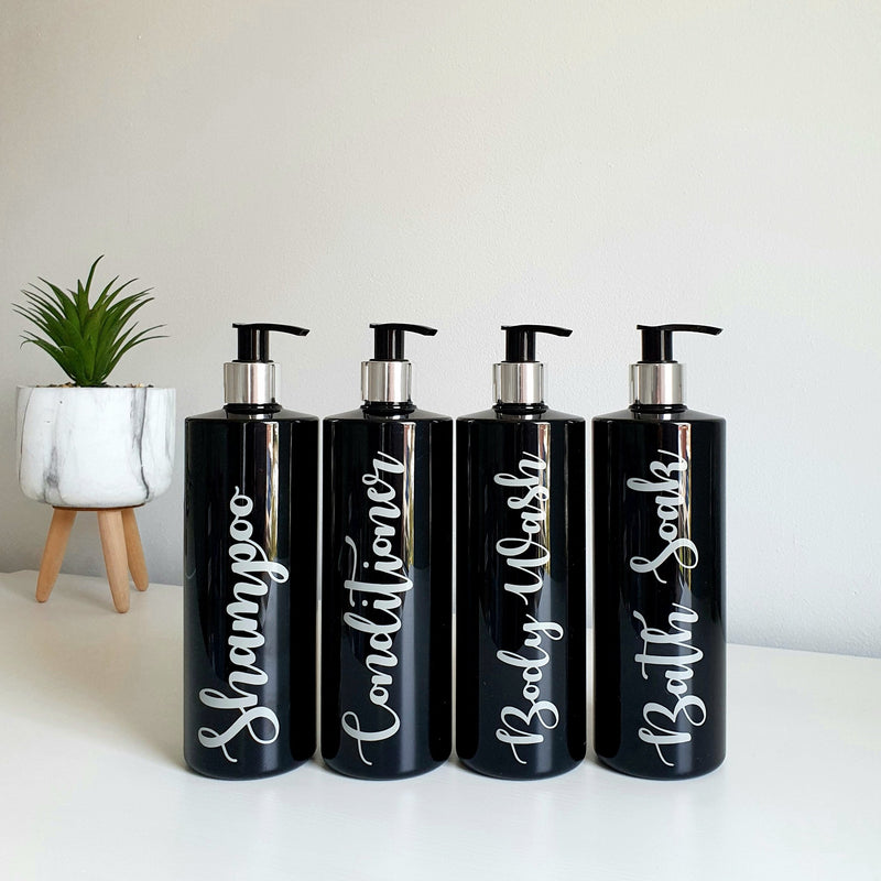 Four 500ml black reusable dispenser pump bottles with labels with Conditioner, Shampoo, Body Wash and Bath Soaks