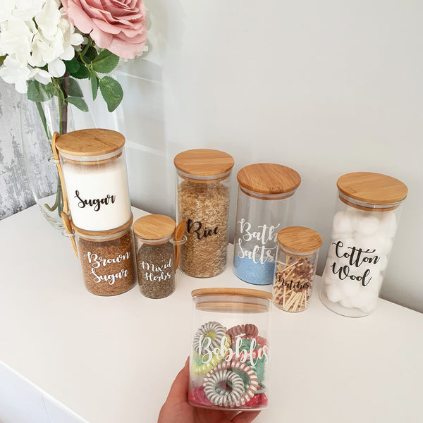 Labelled Glass Jars with Bamboo Lids of varying sizes, with custom personalised wording on the face of the glass.
