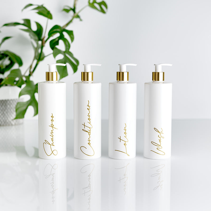 Four white and gold pump dispenser bottles with gold custom personalised wording for Shampoo, Conditioner, Lotion and Wash