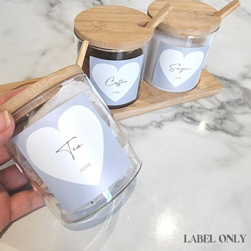 square grey tea coffee sugar labels with cream love heart design and script text inside love heart, Stuck onto glass jars with bamboo lids on white and grey marble kitchen countertop